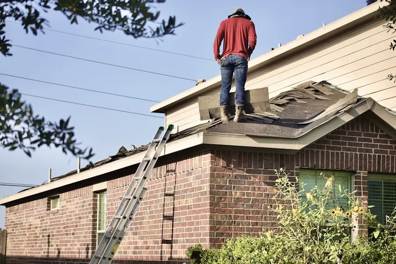 Professional roofer working on a residential roof in Primera